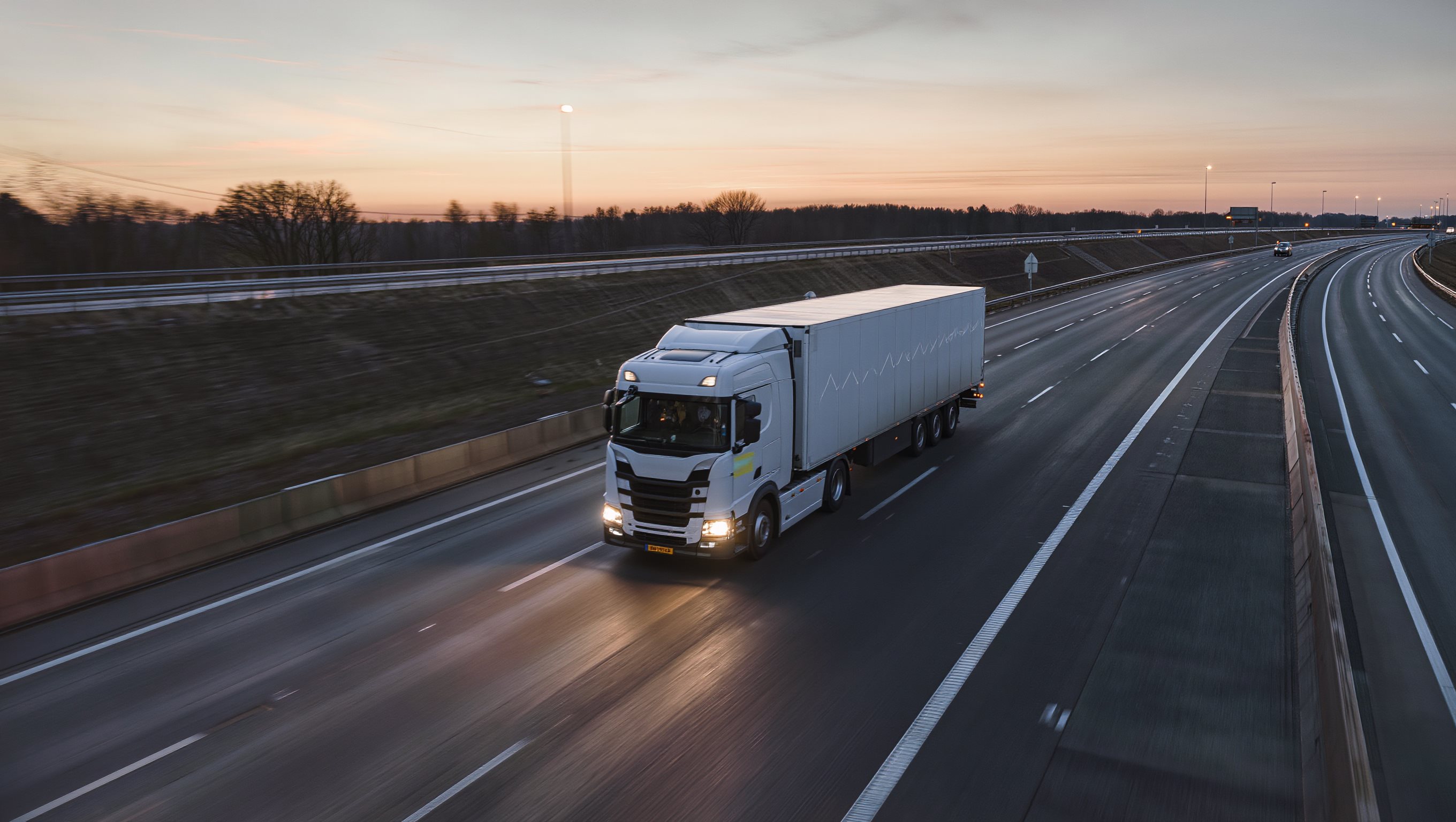 Vrachtwagen op de snelweg bij schemering